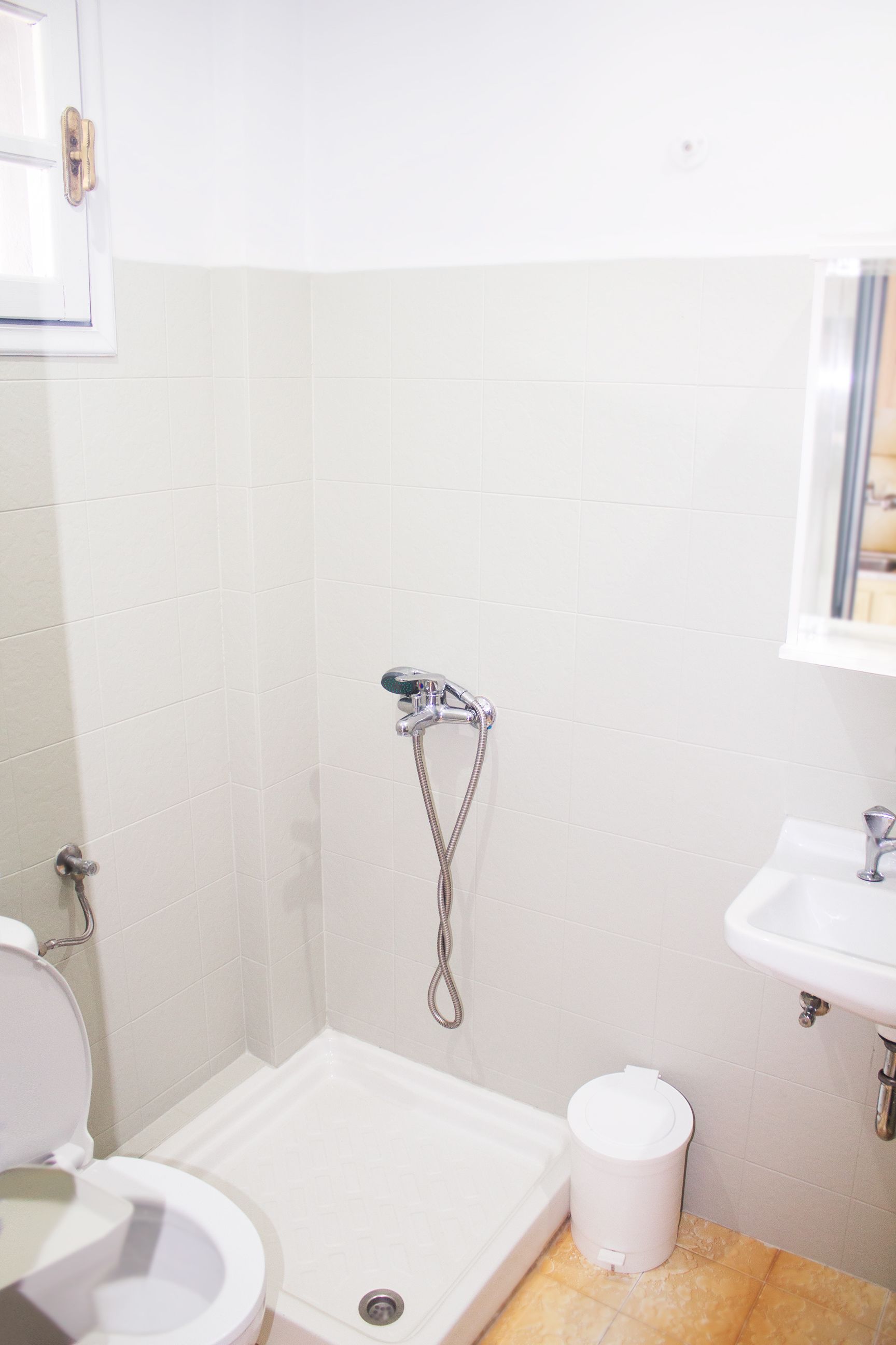 A bathroom with a shower, toilet, and sink.
