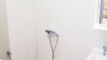 A bathroom with a shower, toilet, and sink.