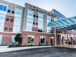 Un hotel moderno con un letrero llamativo, amplias ventanas y un acceso cubierto.
