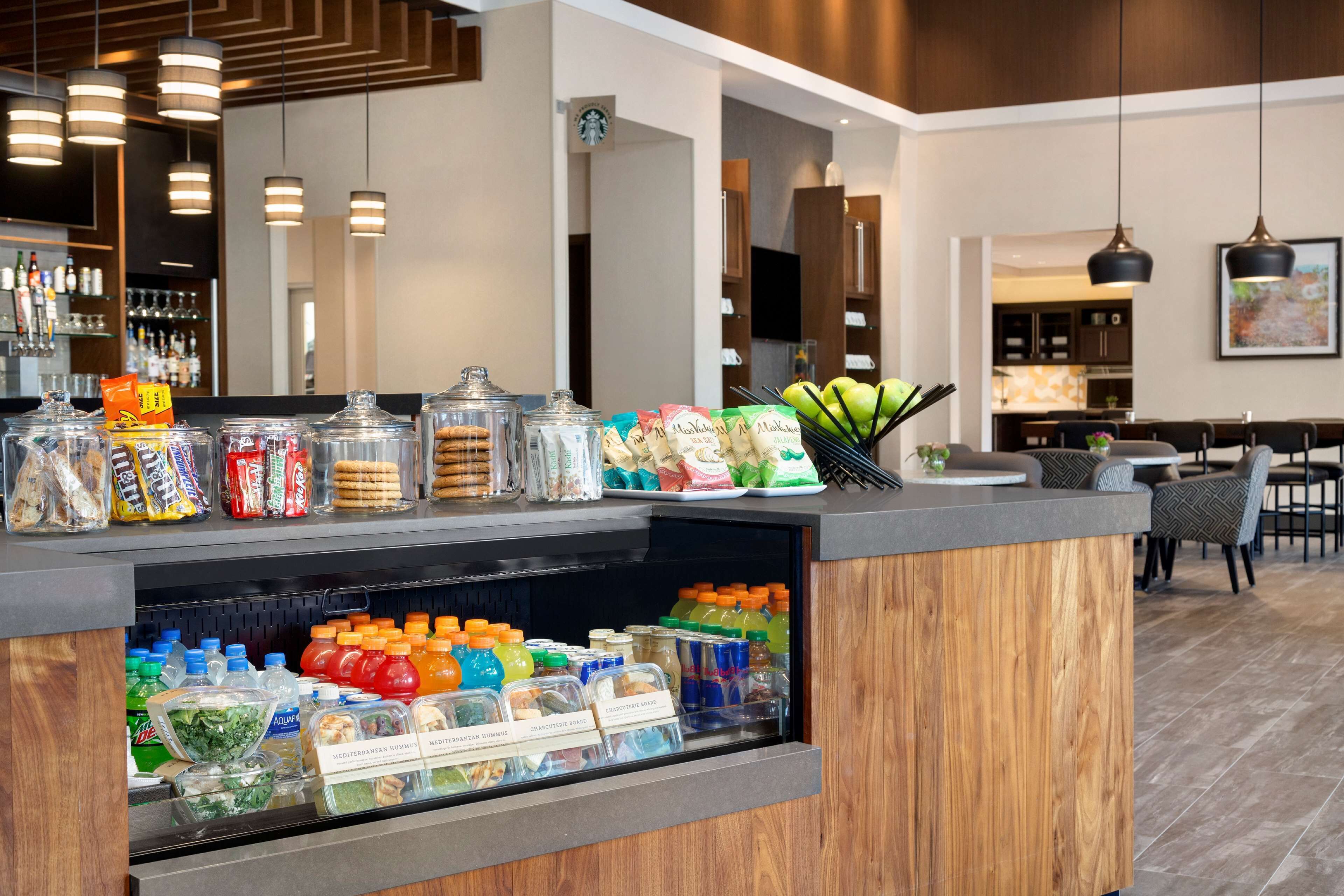 A hotel reception area with a counter displaying snacks, bottled water, and juice.