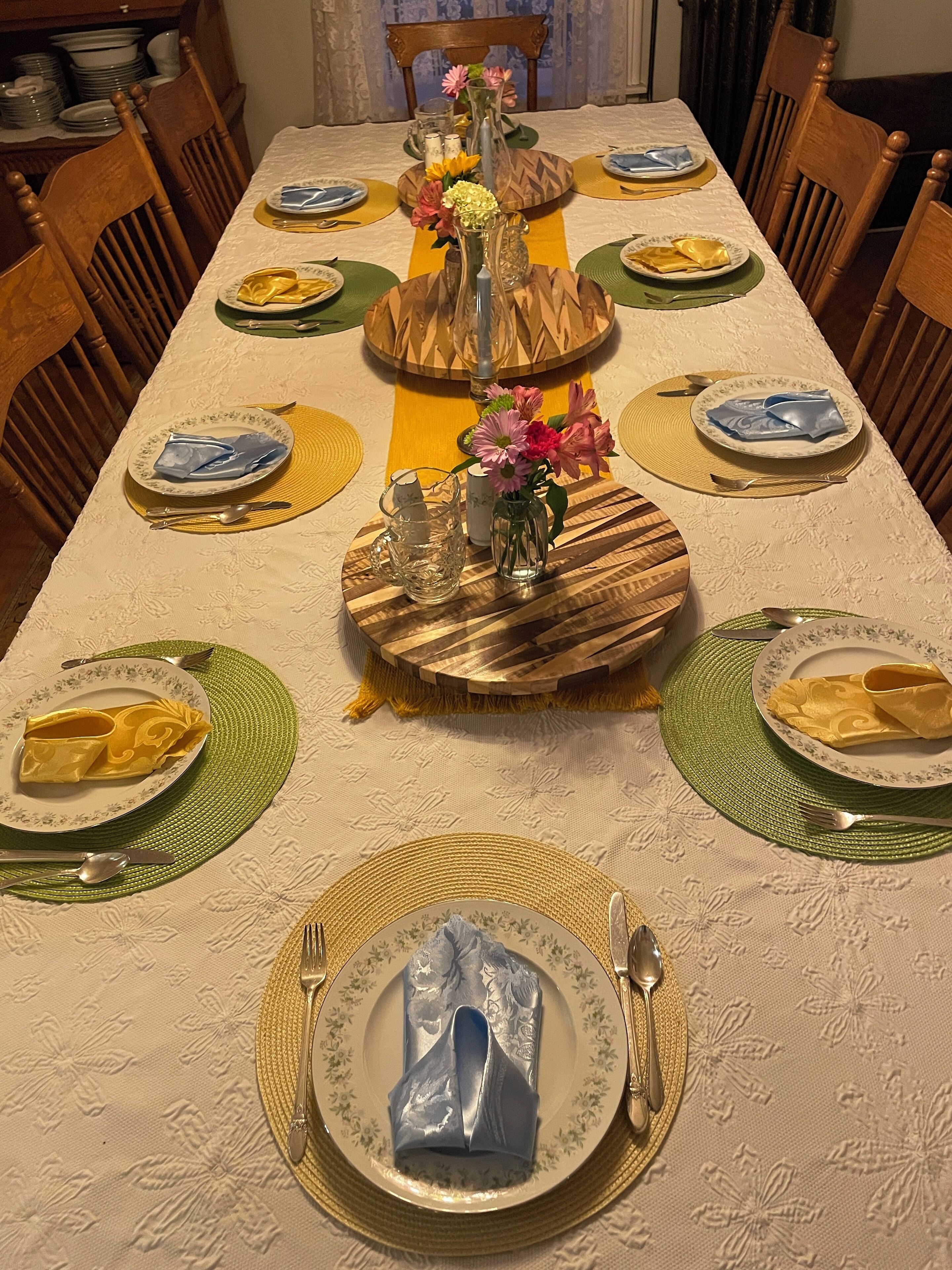 Une table à manger dressée avec des assiettes, des couverts et des serviettes.