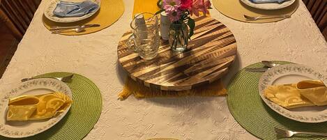 Une table à manger dressée avec des assiettes, des couverts et des serviettes.