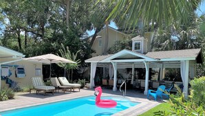 A swimming pool with lounge chairs and a flamingo float. - NEW RESORT-STYLE POOL, CUTE HOUSE, 88 STEPS TO SAND! (Hilton Head Island)