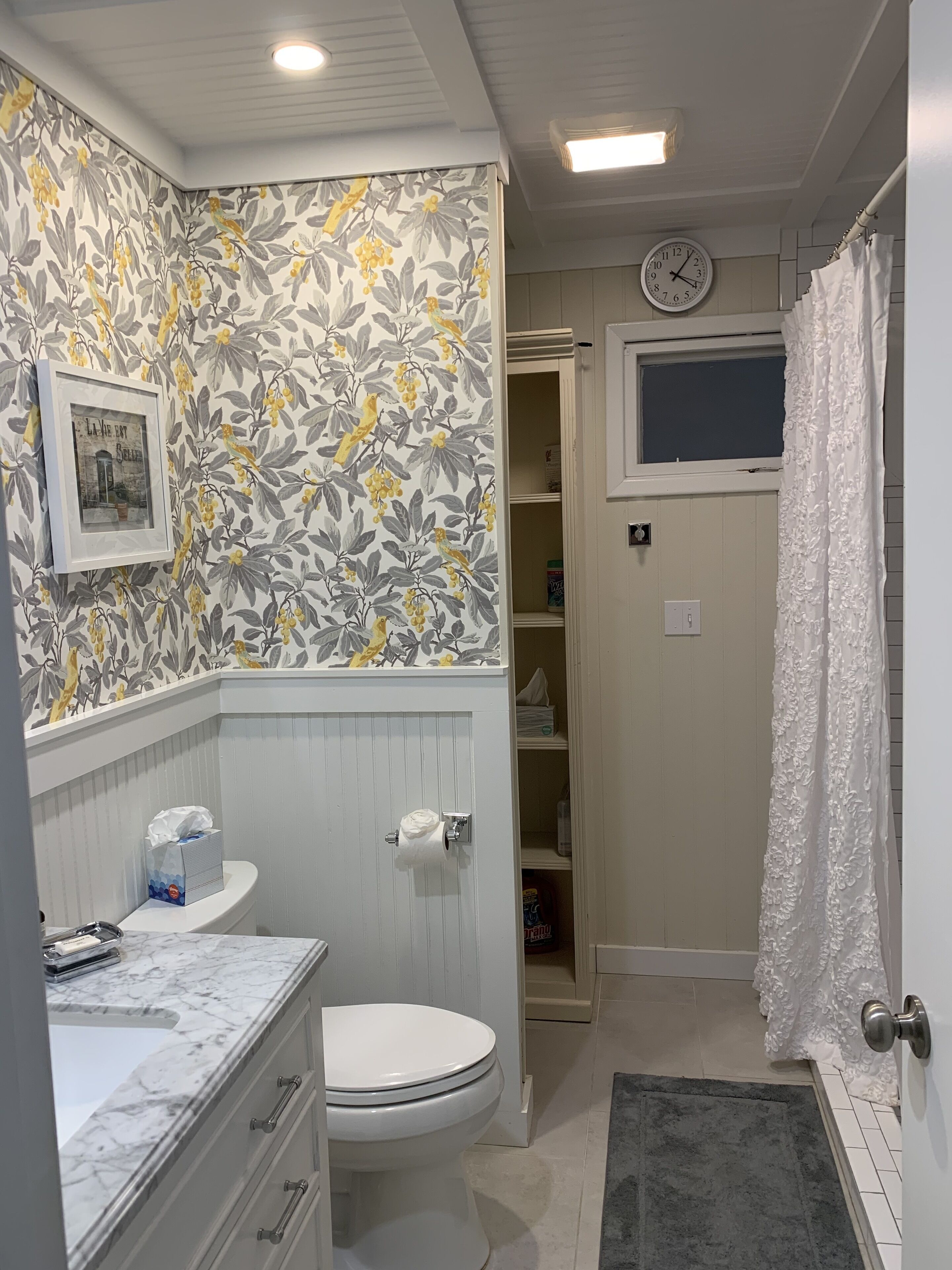 A bathroom with a toilet, sink, and a shower area.