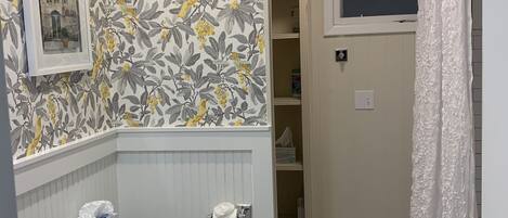 A bathroom with a toilet, sink, and a shower area.