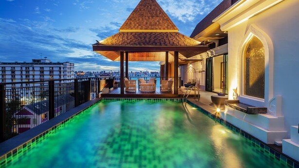 A rooftop pool with a wooden gazebo, a view of the cityscape, and a white building with a balcony. - Grand Sala Thai (Bangkok)
