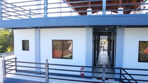 A multi-level building with a central corridor, railings, and a fire extinguisher. - Keen's Place (Puerto Princesa)