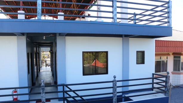A multi-level building with a blue exterior, a visible staircase, and a fire extinguisher near the entrance. - Keen's Place (Puerto Princesa)