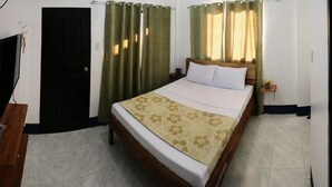 A bedroom with a bed, curtains, a nightstand, and a wooden headboard. - Keen's Place (Puerto Princesa)