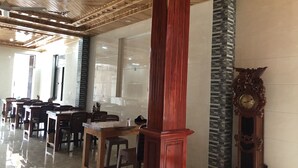 A spacious indoor area with wooden ceiling beams, a polished floor, and a large red pillar. - Starlet Hotel (Phong Nha)