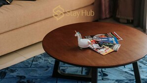 A cozy living room with a sofa, pillows, a coffee table with a decorative unicorn, and a 'Stay Hub' sign. - I City Theme Park Lux Home_link to mall_near UITM SCCC (I-City)