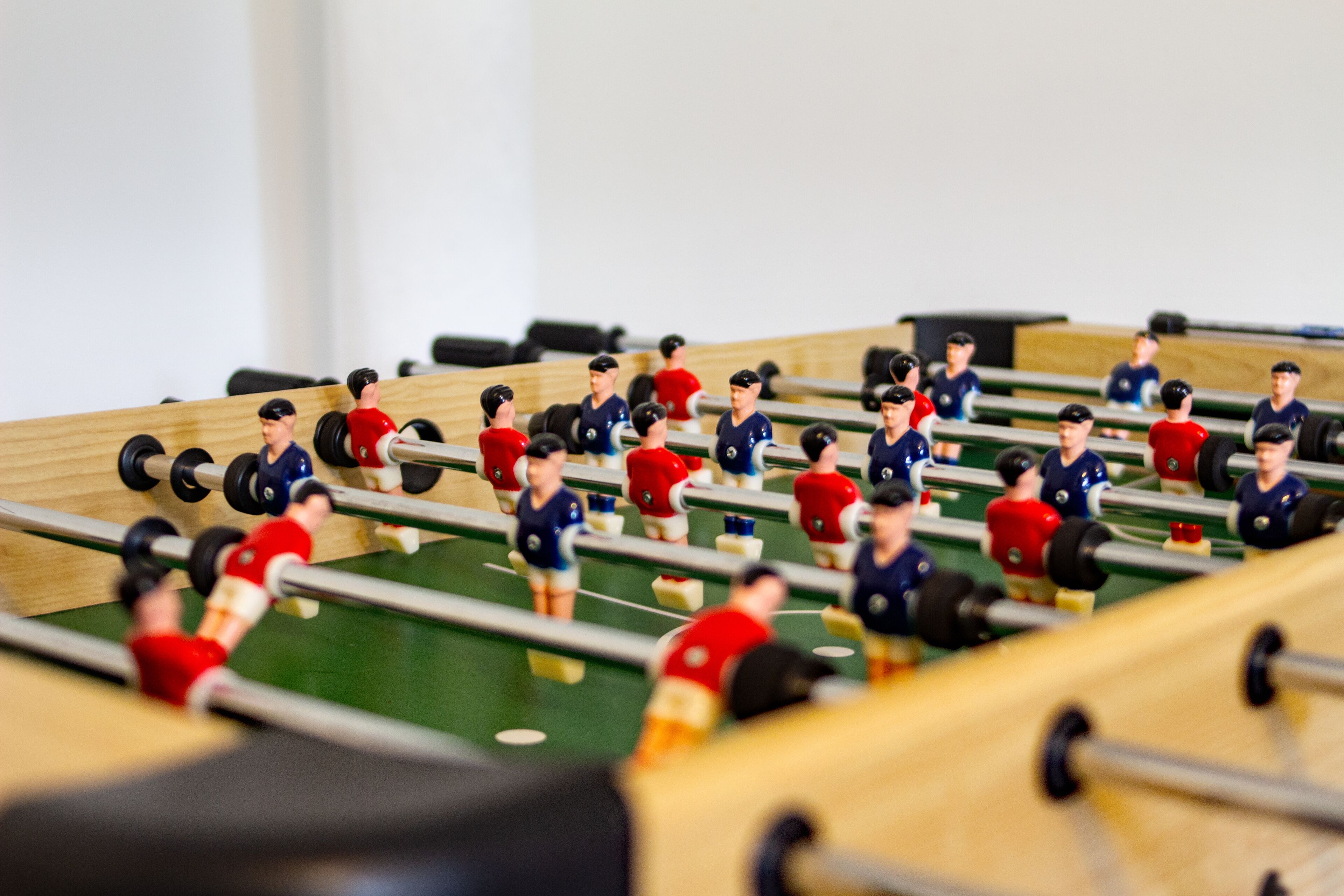 Una mesa de fútbol de mesa con jugadores de uniforme rojo y azul.