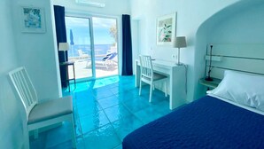 Una habitación de hotel con cama, escritorio, silla y vista al área de la piscina.