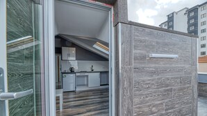 A modern kitchen with white cabinets and a dark wood floor. - Grisverde Suites Hotel (Istanbul)