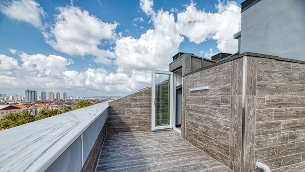 A rooftop terrace with a city view, a glass door, and a wooden wall. - Grisverde Suites Hotel (Istanbul)