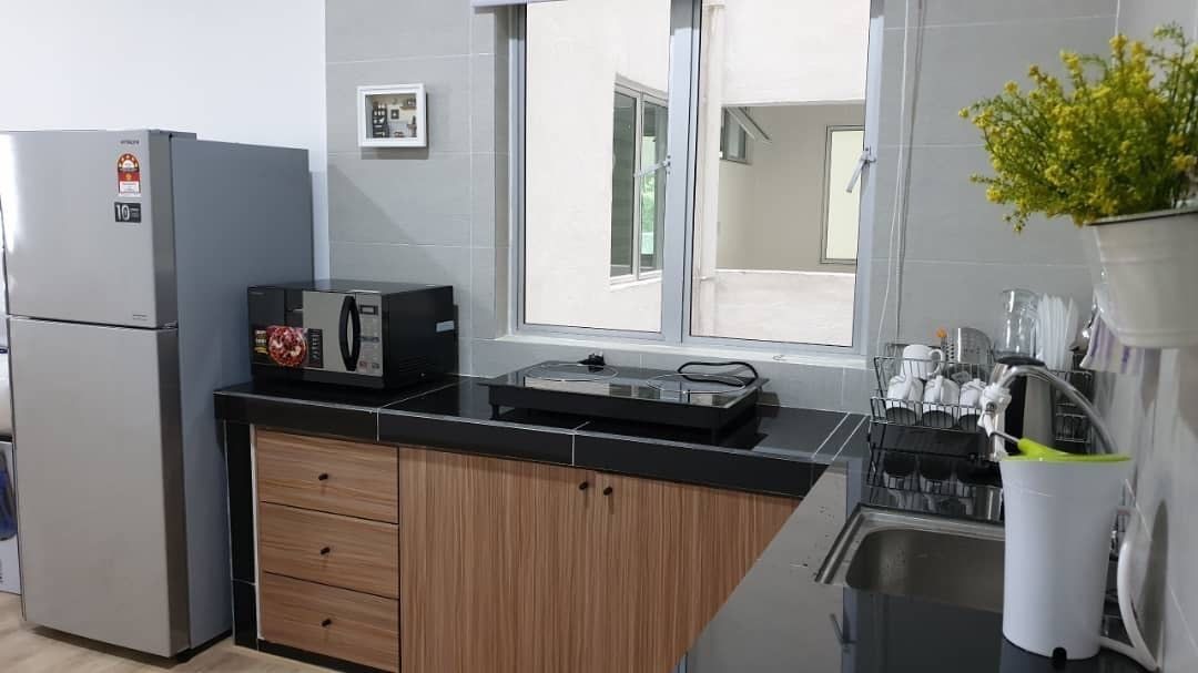 Une cuisine moderne équipée d’un réfrigérateur, d’un four à micro-ondes et d’un évier.