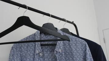 Un perchero con una camisa estampada y una chaqueta oscura.