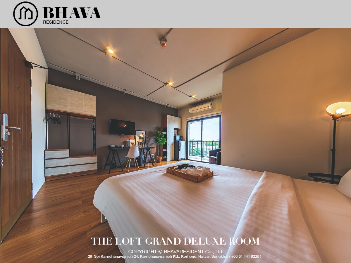 A spacious loft room with a large bed, a desk, and a balcony.