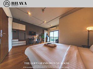 A spacious loft room with a large bed, a desk, and a balcony. - Bhava Residence (Hat Yai)