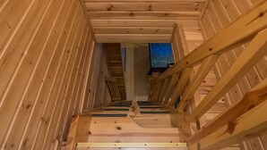 Een houten trap met uitzicht op een kamer boven.