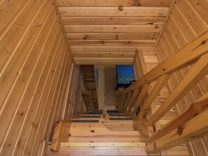Una escalera de madera que conduce a una habitación con vistas a una noche estrellada.