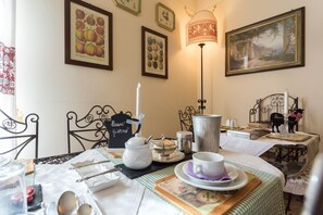 A dining area with a table set for two, featuring a candle, a teapot, and a cup. - New Day Bed & Breakfast (Assisi)