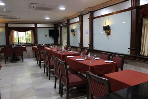 A conference room with tables set for a meeting, equipped with nameplates and tableware.