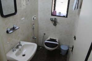 A small bathroom with a sink, toilet, and shower.