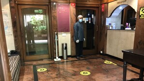A hotel reception area with a marble floor, a reception desk, and a man standing in the doorway. - Hotel Park View Mumbai (Mumbai)