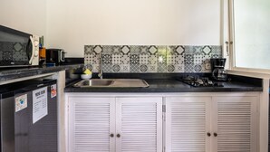 A kitchen with a sink, a coffee maker, and a mini bar sign.