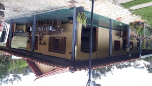Un bâtiment à deux étages, doté d’un toit en tuiles, d’un balcon avec une balustrade et d’une fenêtre avec un volet.