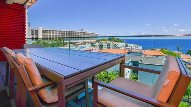 A balcony with a table and chairs, overlooking a cityscape and the ocean. - Apartment Astrolab (Funchal / Madeira - Portugal)