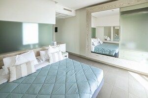 Ein Schlafzimmer mit einem großen Bett, einem Nachttisch, einem Spiegel und einem Kleiderschrank.