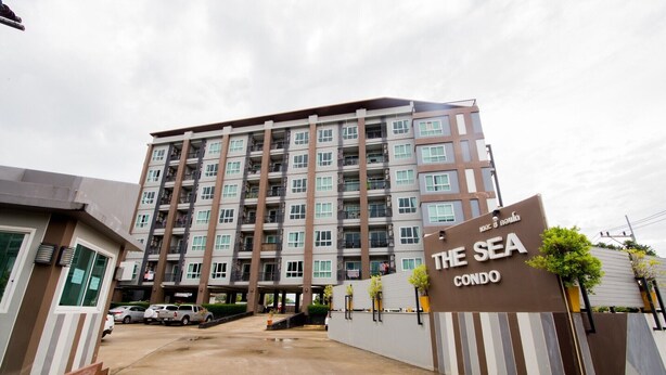 A multi-story building labeled "The Sea Condo" with a parking area in front.