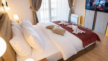 Una habitación de hotel con una cama grande, televisión y cortinas.