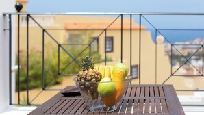 En gennemsigtig skål med frugt på et bord på en balkon.