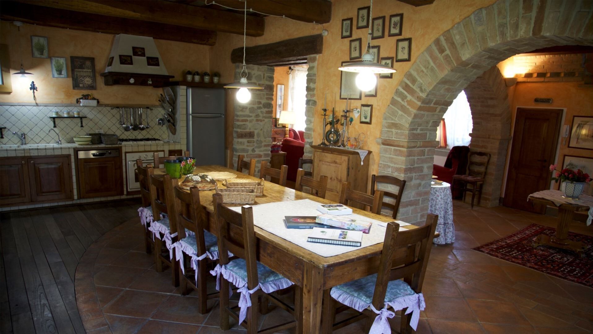 A rustic kitchen with stone walls, wooden furniture, and a dining area with a large table.
