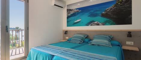 Ein Schlafzimmer mit einem Bett, einem großen Fenster und einer Wand-Klimaanlage.