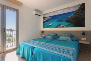 A bedroom with a bed, a large window, and a wall-mounted air conditioner.