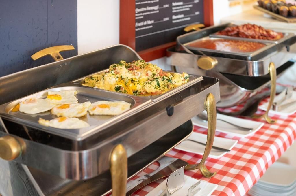 A buffet with various food options, including eggs and a dish with greens and cheese.