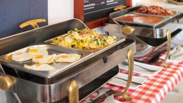 A buffet with various food options, including eggs and a dish with greens and cheese.
