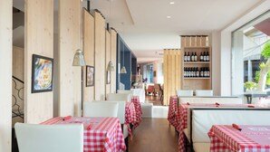 A restaurant interior with checkered tablecloths, white chairs, wooden panel walls, and a wine rack. - Eolo Affiliated by FERGUS (Pollenca)