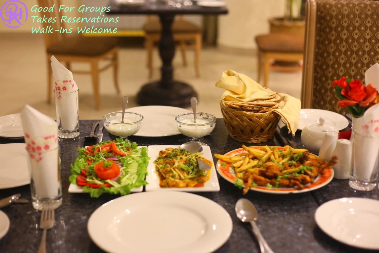 A dining table set with various dishes, including salads, a plate of fries, and bowls of soup.