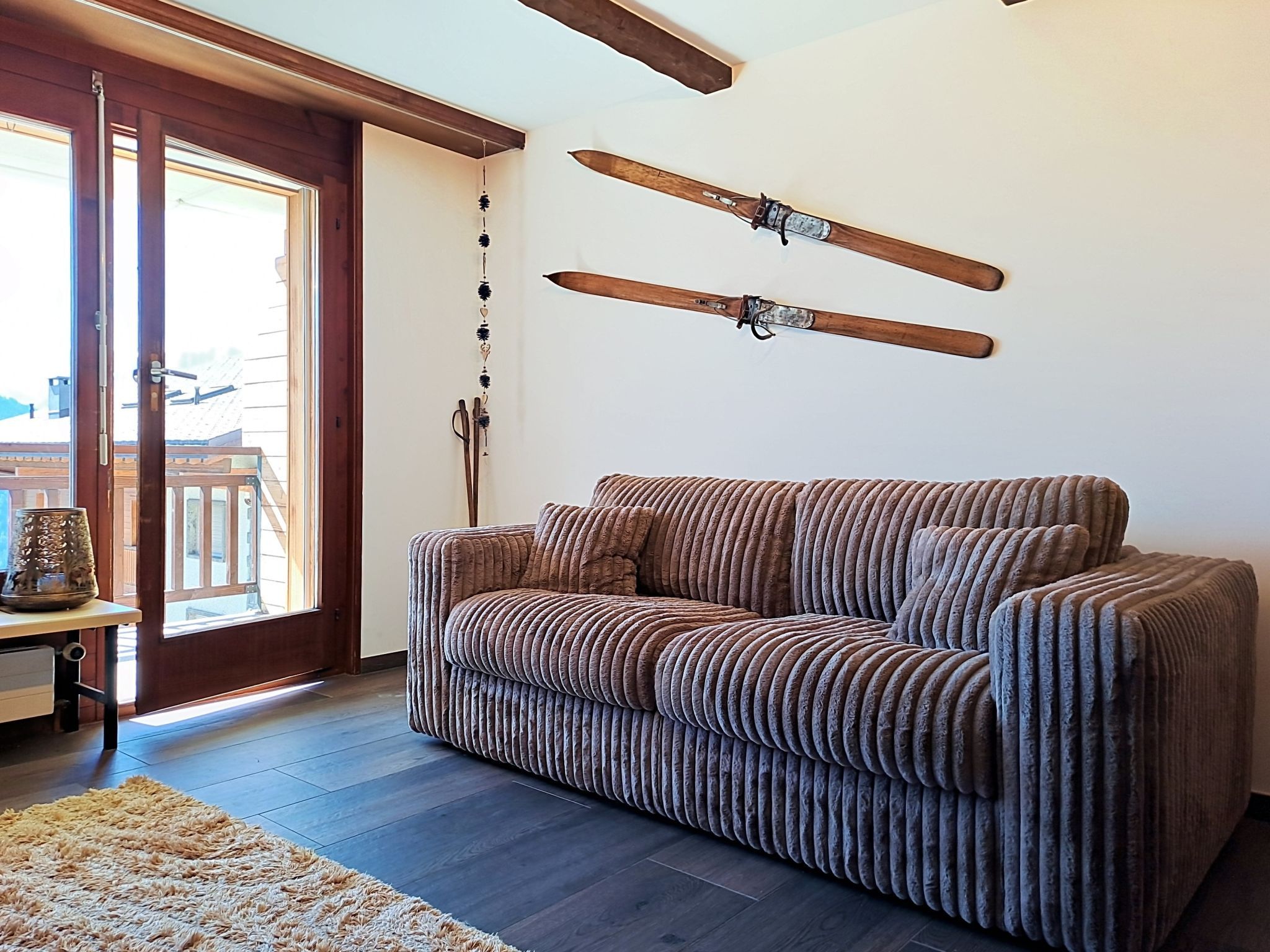 Un salon avec un canapé, une porte en bois et une fenêtre.