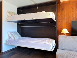 Una cama litera con una cama inferior y un escritorio extraíble.