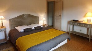 Un dormitorio con cama, mesitas de noche y una pequeña mesa auxiliar.