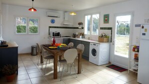 Cocina compacta con comedor, lavadora y refrigerador.