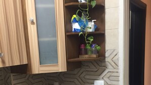 Eine kleine Küche mit Holzausstattung, einer Waschmaschine und einem Regal mit einem Blumentopf.