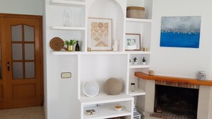 A living room with a fireplace, white shelving, and a door with glass panels. - Beautiful villa, swimming pool, tennis court, basketball court, garden, sea view, near beaches (El Vendrell)
