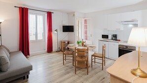 A modern apartment with a dining area, kitchen, and living space.